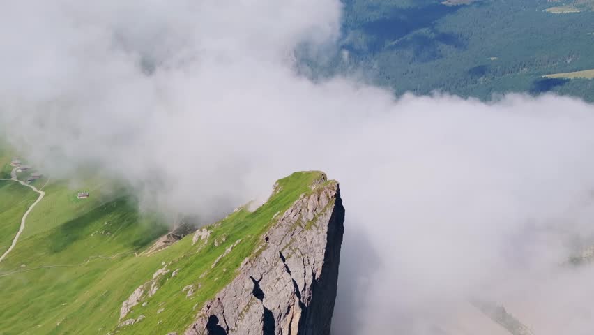 Peaceful nature drone shot showing harmony between earth clouds and mountain top