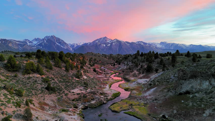 Aerial view ascending in front of a winding river, sundown in Hot Creek, CA, USA