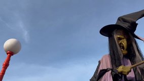 A tall witch figure stands holding a magic wand, the Halloween decoration. - Powered by Shutterstock - Get 15% off with code: PIKWIZARD15