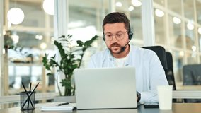 Focused call center specialist works diligently on a laptop in a bright, modern office. The confident businessman, dressed in a light blue shirt, wears a headset, engaged in online communication. - Powered by Shutterstock - Get 15% off with code: PIKWIZARD15