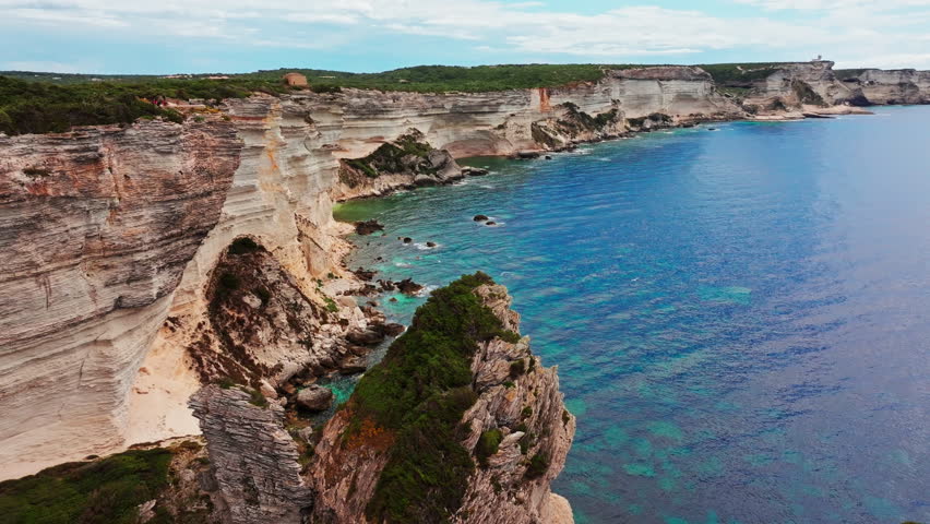 Aerial drone shot over the stunning rugged coastline of southern Corsica, France.