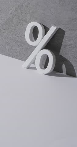 Vertical video of white percent sign with copy space against grey background. Black friday, cyber monday, shopping, cyber shopping, sales, retail and shipping concept.