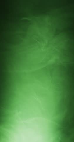 Vertical video of green clouds of smoke moving with copy space on black background. Halloween, spooky background and movement concept digitally generated video.