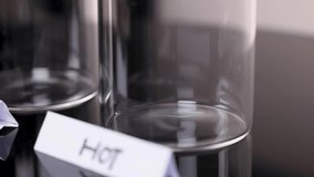 Hot water poured into clear glass beaker, creating swirling motion, under bright studio lighting - Powered by Shutterstock - Get 15% off with code: PIKWIZARD15