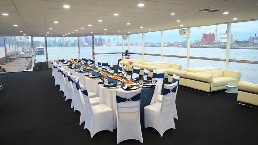 Luxury dining room with river view in New York City. Elegant dining room set up with tables and decorations overlooking the East River and city skyline in New York City.