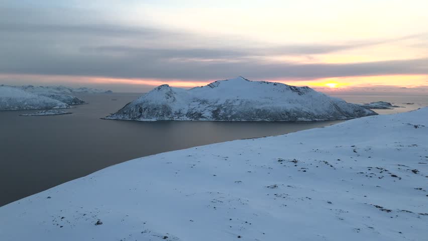 Aerial view over mountain revealing fjord at sunset