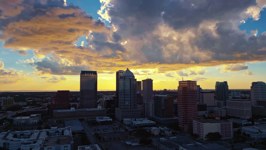 Glowing morning skyline of Tampa with warm clouds, aerial tracking right, establish