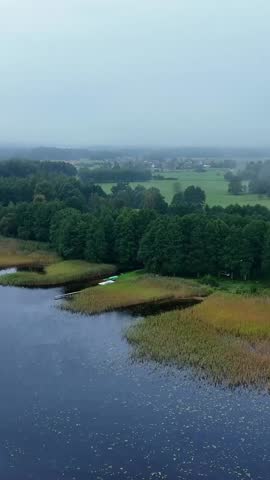 A serene view of Usma Lake in Latvia with lush green forests and water