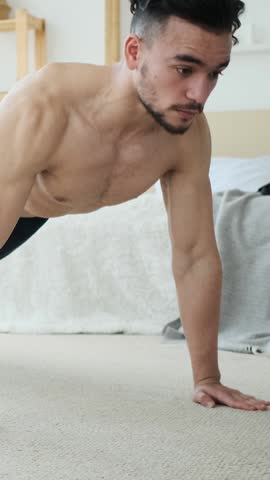 Young man doing push-ups during a home workout.