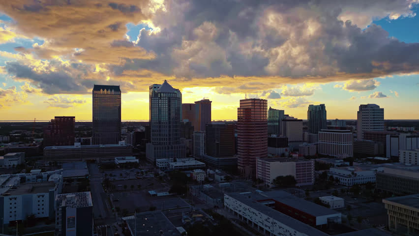 Sunset at dusk in downtown Tampa with massive dramatic clouds of yellow and blue in the sky with soft warm light all around.