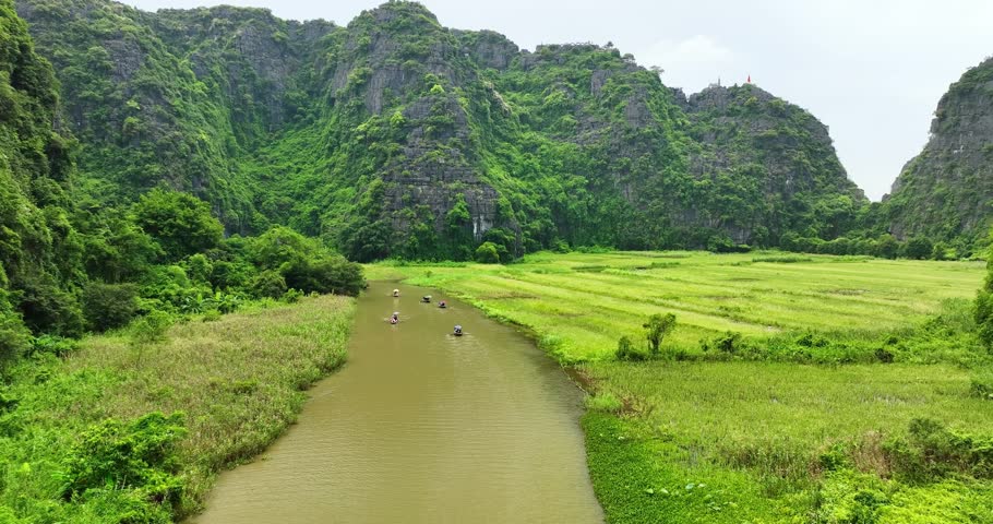 Aerial view of Tam Coc landscape with limestone mountains, river and rice field on stream in Ninh Binh, Vietnam