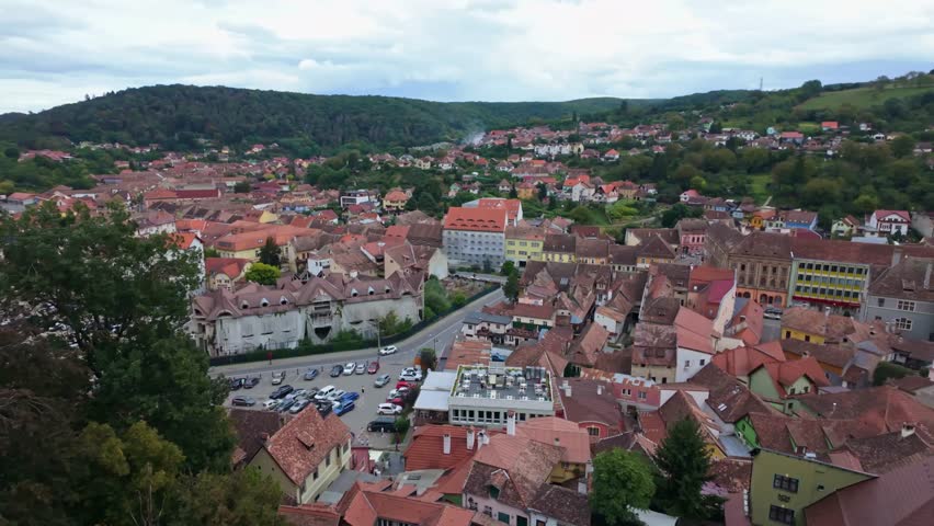 Panoramic view from the colorful traditional townscape with surrounding green hills of Sighișoara in Romania.