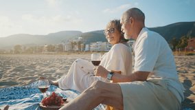 Affectionate elderly couple enjoying a romantic moment together during a picnic on a sandy beach at sunset, showing love, tenderness, and a happy retirement lifestyle by the sea - Powered by Shutterstock - Get 15% off with code: PIKWIZARD15