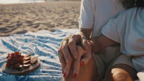 Affectionate elderly couple enjoying a romantic moment together during a picnic on a sandy beach at sunset, showing love, tenderness, and a happy retirement lifestyle by the sea - Powered by Shutterstock - Get 15% off with code: PIKWIZARD15