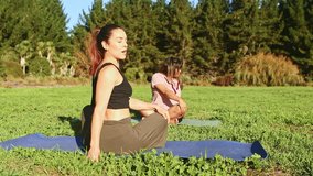Serene yoga session unfolding on grassy park ground, featuring Latin and Indian women practicing mindful meditation surrounded by lush landscape - Powered by Shutterstock - Get 15% off with code: PIKWIZARD15