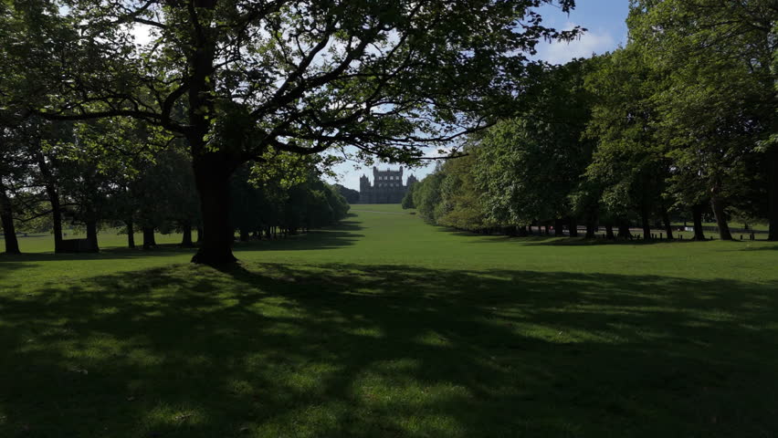 Nottingham, UK, 09-05-2025: Stunning aerial approach shot through trees to view of Wollaton Hall located in Wollaton Park in Nottingham.