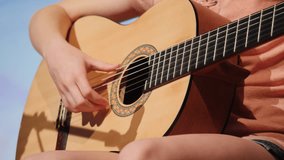 Talented female musician playing chords on a classical acoustic guitar during a sunny day - Powered by Shutterstock - Get 15% off with code: PIKWIZARD15
