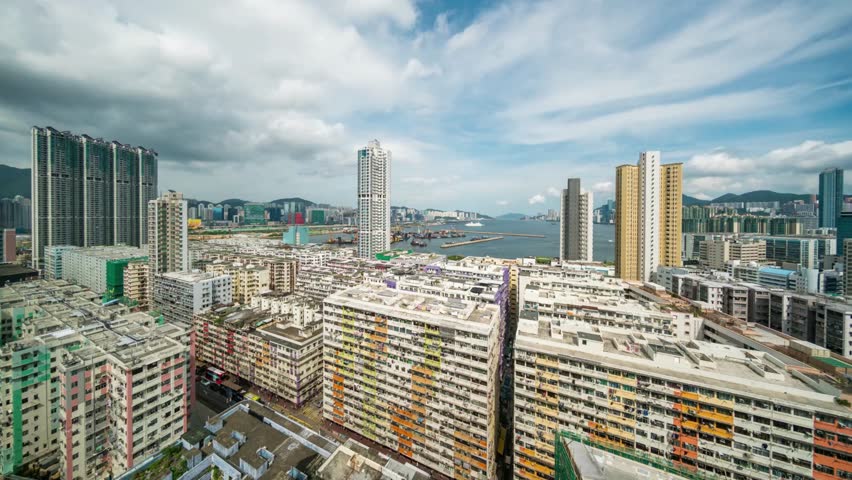 Aerial view of Hong Kong cityscape with colorful buildings under cloudy blue sky