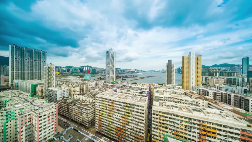 Aerial view of Hong Kong cityscape with modern buildings under a bright blue sky