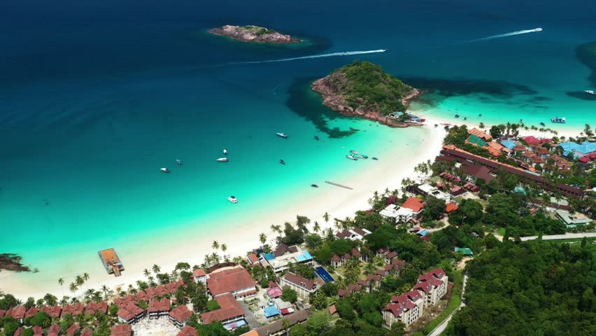 A tropical beach in the popular Redang Island resort with clear turquoise waters and lush greenery surrounded by small islands. Malaysia