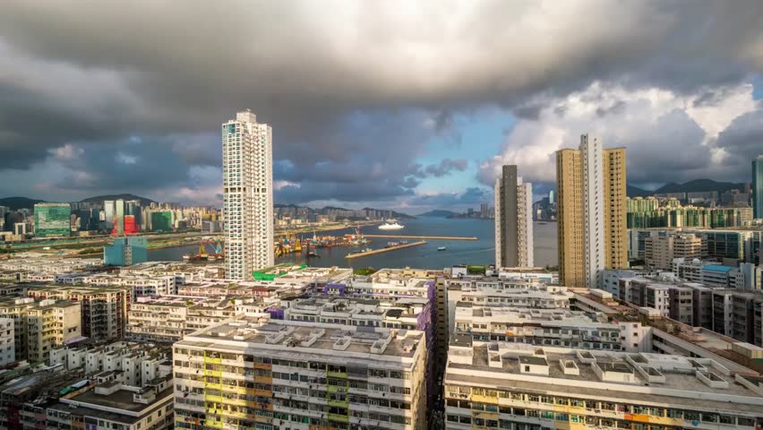 Aerial view of Hong Kong cityscape with harbor and cloudy sky at twilight time