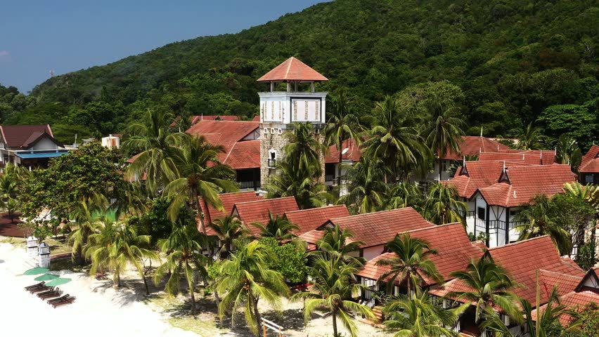 A resort surrounded by palm trees and hills in a tropical paradise on Redang Island. Long Beach. Malaysia
