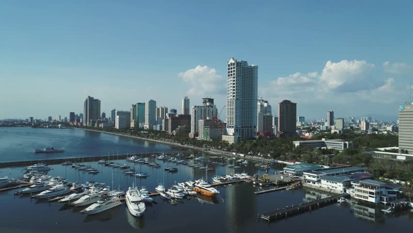 Manila skyline and harbor with yachts under a blue sky on a sunny day in the city