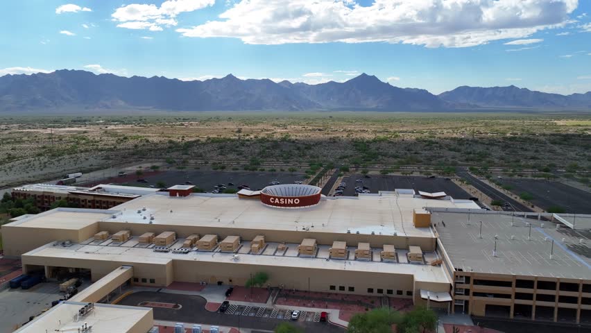 Aerial view of Vee Quiva Casino, a desert oasis with parking lots and mountainous backdrop, creating a stark contrast, Laveen Village, Arizona, United States.