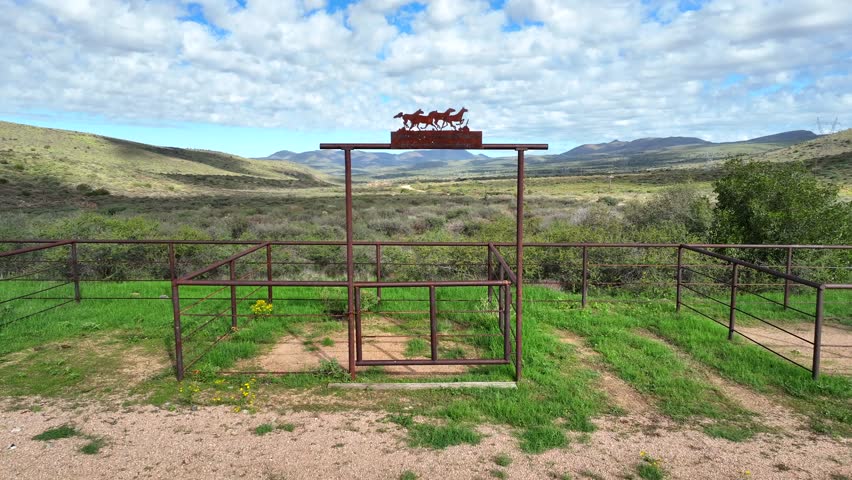 Aerial view of desert landscape with shrubs and distant mountains under a cloudy sky, creating a sense of vastness, Scottsdale, Arizona, United States.