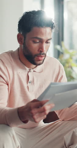 Moving, paperwork and man with stress in lounge, overwhelmed or reading contract for title transfer. Real estate, frustrated and person with mortgage document, worry and financial cost for relocation