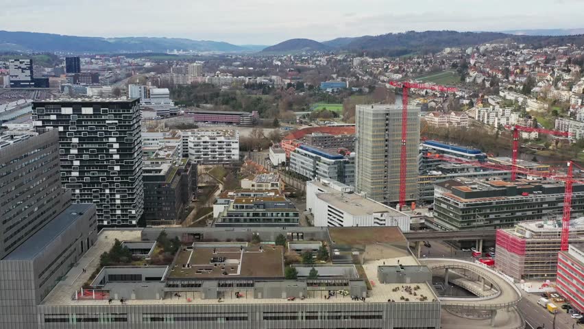 Aerial view of buildings and cranes creating a skyline of urban development, the city sprawling into the distant hills, Zurich, Zurich, Switzerland.