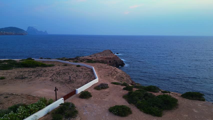 dancing Woman expressing freedom and movement by the sea at a beautiful travel destination Cala Llentia Ibiza. Unique aerial view flight overflight flyover drone