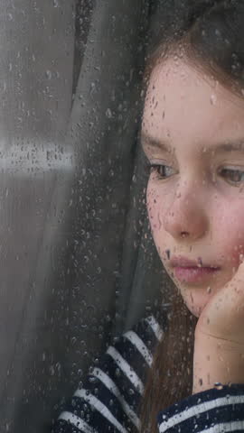Portrait Caucasian little girl child kid looking out window rainy weather suffering with lonely look at rain orphan waiting for custody adoption problem family trouble daughter sadness isolation grief