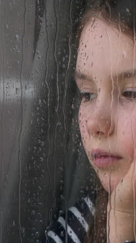 Portrait Caucasian little girl child kid looking out window rainy weather suffering with lonely look at rain orphan waiting for custody adoption problem family trouble daughter sadness isolation grief