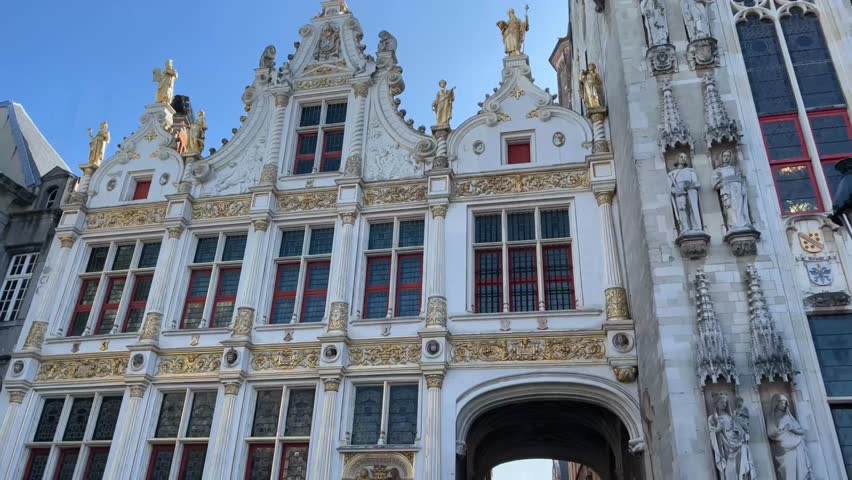 Tourist passing through the Brugse Vrije arch in Bruges, Belgium