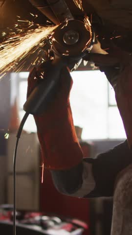 Animation of glowing light over caucasian female car mechanic working in workshop. labor day, work, workers, tradition and celebration concept digitally generated video.