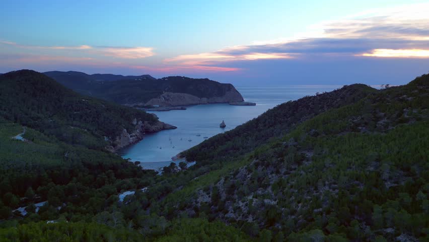 Ibiza Cala Benirras bay coastline at sunset. Best aerial view flight drone