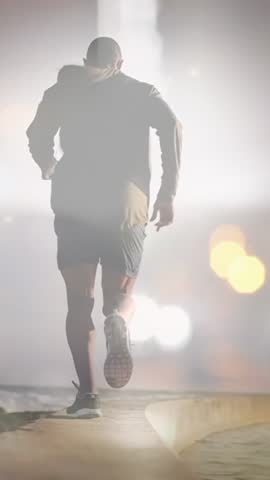 Composite of man running by the sea, and city traffic and lights at night. health, fitness and wellbeing concept digitally generated video.