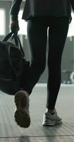 Fitness, legs and walking with bag in gym to start workout, sports training and wellness practice. Athlete, woman and arrival with gear at health club for exercise preparation and physical activity