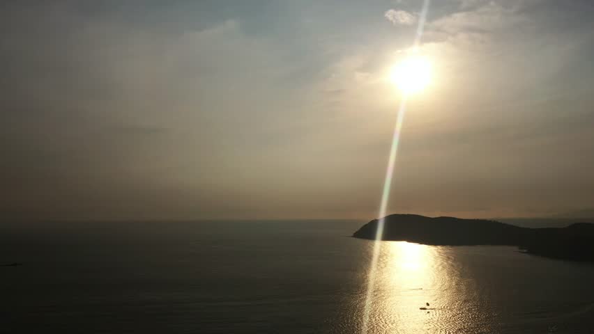 Stunning sunset over the serene ocean waves near Langkawi Island, reflecting golden light on a quiet coastline in the late evening in a tropical paradise