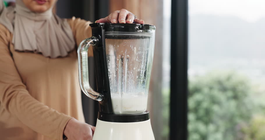 Muslim, hands and woman with smoothie in blender for breakfast shake, digestive health and detox. Islamic person, machine and beverage preparation in home for meal replacement, healthy diet and space