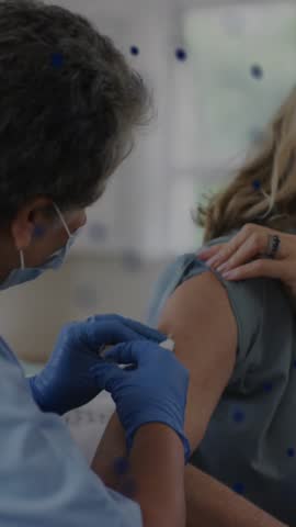 Animation of spots over african american female doctor vaccinating patient. senior home hangout and digital interface concept digitally generated video.