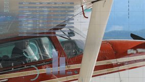 Male pilot monitoring flight metrics while view of red plane initiating transparent data overlay. Aviation, cockpit, data visualization, analytics, transportation, aircraft, dashboards - Powered by Shutterstock - Get 15% off with code: PIKWIZARD15