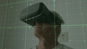 Senior man wearing VR headset initiating green grid overlay and scanning immersive simulation. Technology, innovation, digital, futuristic, gaming, entertainment, computer - Powered by Shutterstock - Get 15% off with code: PIKWIZARD15