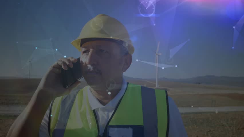 Field engineer holding phone to ear, starting wind farm check while using AR overlays on turbines. Technology, innovation, sustainability, renewable, digital, outdoor, professional - Powered by Shutterstock - Get 15% off with code: PIKWIZARD15