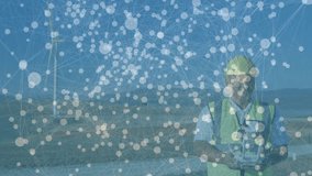 Powering controller, field engineer monitoring telemetry on wind farm with data overlay. Renewable, technology, automation, sustainability, engineering, digital, outdoors - Powered by Shutterstock - Get 15% off with code: PIKWIZARD15