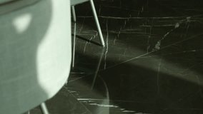 Close up view of modern interior highlights dark, polished marble floor with striking white veining. Glossy surface reflects light and nearby furniture adding depth - Powered by Shutterstock - Get 15% off with code: PIKWIZARD15