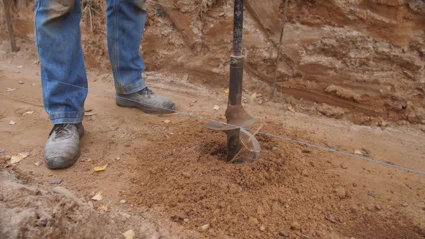 technician performs precise manual auger drilling, scientist skillfully drills test hole with careful footing, technician meticulously uses manual auger to expose soil layers scientifically