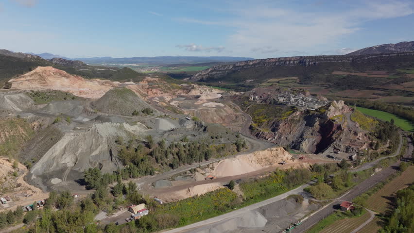 Aerial View of a Quarry in a Mountainous Valley, Highlighting Industrial Activity and Natural Beauty
