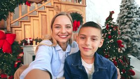 Joyful woman, young boy share happy moments during Christmas video call, smiling, waving. Festive decorations create warm, celebratory atmosphere, conveying holiday spirit, family connection. - Powered by Shutterstock - Get 15% off with code: PIKWIZARD15